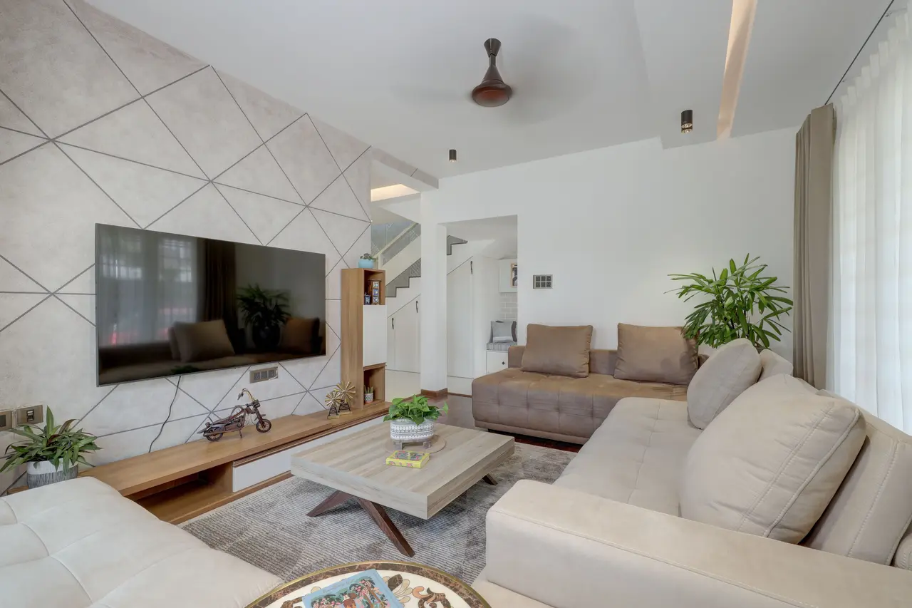 Woonkamer met een geometrische tv-wand, hoekbank en een houten mediameubel