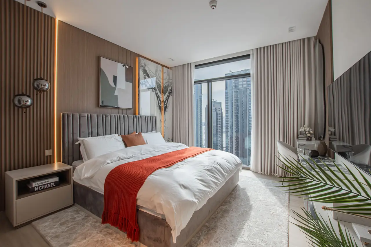 Moderne slaapkamer met een bed met kanaaltufting, geribbelde wand en uitzicht op de stad
