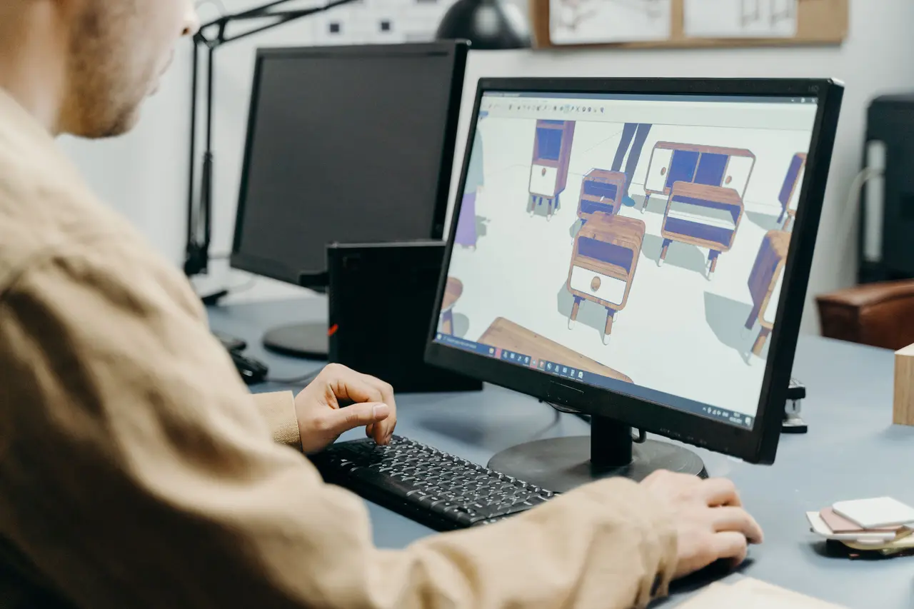 Дизайнер моделює меблі в 3D на екрані комп’ютера